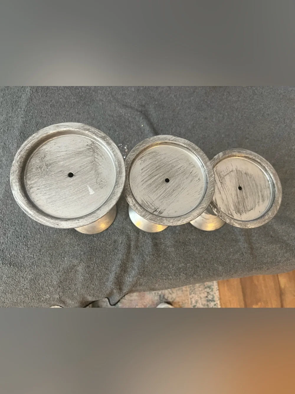 set of three silver-tone metal candlestick holders features a graduated design